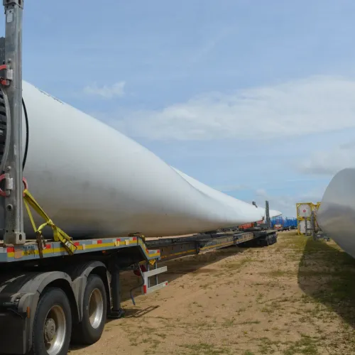 Vista parcial de 2 aspas de molinos para generación eléctrica cargados en camiones