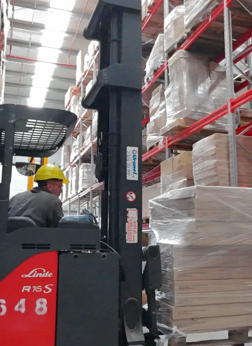 Operario de déposito trabajando con elevador