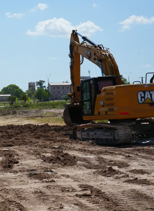 Vista parcial de retroexcavadora trabajando en obra en movimeintos de suelos en Parque Industrial Ruta 5